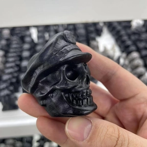 Detailed view of matte black obsidian skull sculpture with a large brimmed hat design