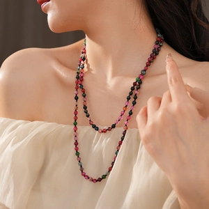 Close-up of bohemian beaded tourmaline necklace with colorful gemstone beads on model