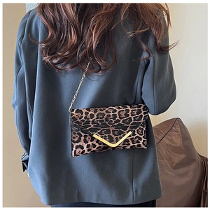 Leopard print envelope clutch with gold V-detail and chain strap on a blazer outfit