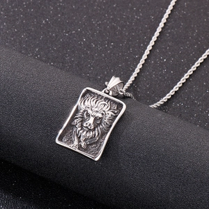 Relief détaillé d'une tête de lion sur un pendentif vintage en acier inoxydable argenté
