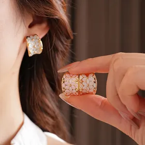 Boucles d'oreilles fleuries en forme de C dorées avec pétales en émail blanc et rose