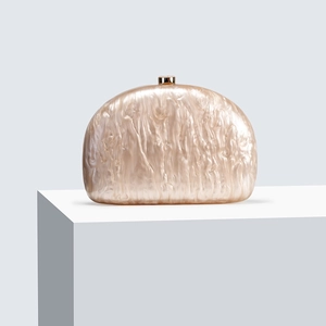 Champagne marble acrylic semi-circle clutch bag with golden clasp on a white stand