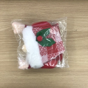Detail view of a red knitted Christmas wine bottle cover in transparent packaging