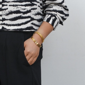 Detail shot of double-layer 18K gold plated bracelet set on female wrist with zircons