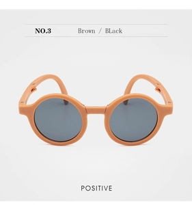 Front view of tan round foldable kids sunglasses with dark lenses and flexible frames