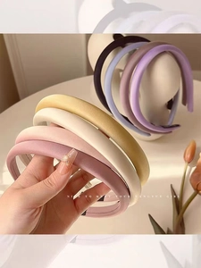 Close-up of five colorful satin hairbands in pink, beige, yellow, purple and dark blue