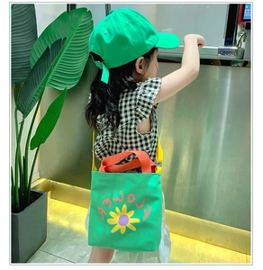 Detail of vibrant green canvas bag with yellow daisy print and flower text on adjustable strap