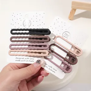 Detailed view of matte duckbill hair clips set in brown tones for stylish bangs