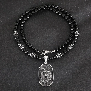 Macro detail of punk wolf head pendant with black agate beads and lobster clasp