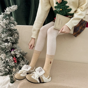 Dettaglio calzini natalizi beige con ricamo a orsetto e sneakers in pile accoglienti
