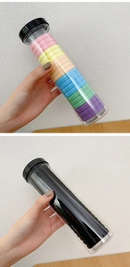 Macro detail of seamless elastic hair ties in colorful and black sets within clear jars