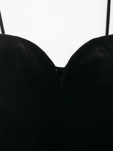Détail du col d'une robe en velours noir avec fines bretelles et texture douce