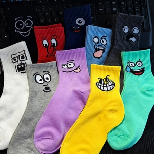 Flat lay of colorful cotton crew socks featuring various cartoon embroidered facial expressions