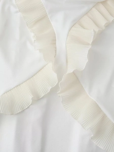 Gros plan sur la dentelle blanche et la texture plissée du tissu d'une robe pour femmes