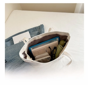 Top view of white textured tote bag showing spacious interior with tablet and daily essentials