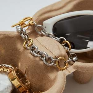Detail of two-tone gold and silver chain bracelet with T-bar clasp on pulp tray