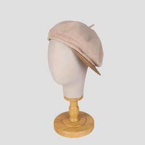 Détail du chapeau en tricot beige montrant la texture fine et la doublure marron