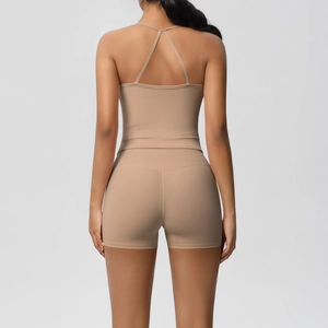Detail of cross-back design on nude sports top with high-waist fitness shorts