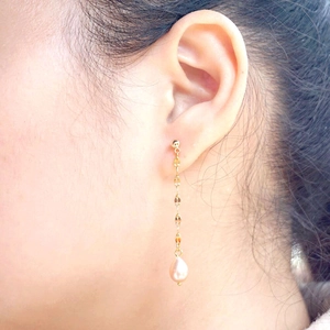 Minimalist gold tassel earrings with leaf-shaped links and teardrop freshwater pearl