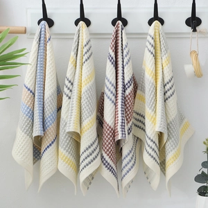 Cotton waffle weave towels with geometric stripes in assorted colors hanging on a rack
