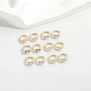 Macro view of 12 pairs of gold pear-shaped earrings with colorful enamel and clear gemstones