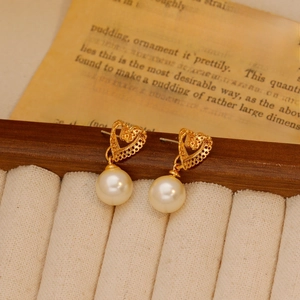Vintage hollow heart earrings with round pearl drops on a minimalist display stand