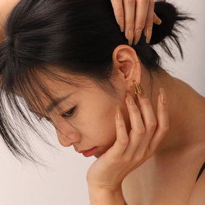 Close-up of 18k gold plated double hoop earrings worn by a model for a luxury look