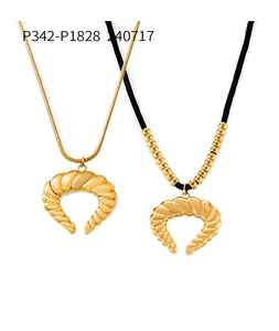 Detail van 18k vergulde hoornhangers met geribbelde textuur aan slangenketting en zwart koord
