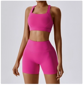 Dettaglio del set yoga rosa acceso con reggiseno sportivo a U e pantaloncini a vita alta