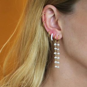 Close-up of S925 silver asymmetric pearl tassel earrings and golden ear cuffs on a model