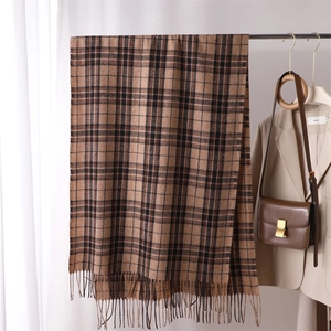 Close-up of brown plaid imitation cashmere scarf with tassels on a hanger