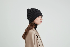 Close-up of black ribbed knit beanie on model showing thick wool texture for winter