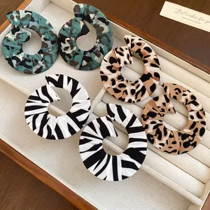 Set of three pairs of spiral fabric earrings with animal prints in a velvet display tray