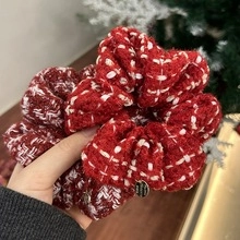 Close-up of red and white tweed scrunchies with pearl bow detail and knit texture