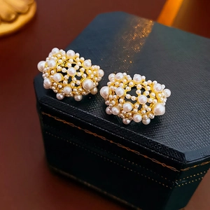 French vintage gold plated earrings with cluster pearls on dark blue jewelry box