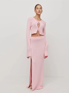 Detail of pink knitted set showing tie-front cardigan and side-slit maxi skirt texture