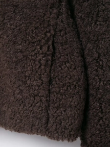 Close-up detail of high-density brown lamb wool fabric texture for warm thick jackets