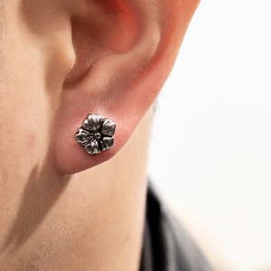 Retro silver flower stud earring made of cast stainless steel shown on ear model
