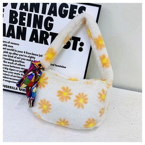 Detail of white plush handbag with yellow daisy patterns and a colorful silk scarf accent