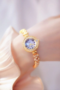 Close-up of luxury gold women's watch with crystal-encrusted band and Roman numerals