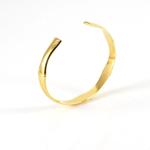 Vue latérale détaillée d'un bracelet jonc en acier doré avec texture bambou et bout ouvert