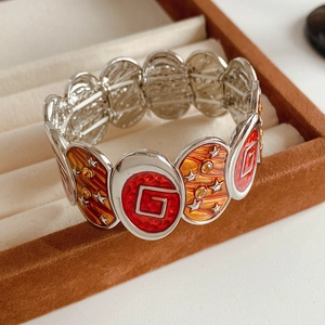 Détail du bracelet vintage en émail avec logo G et étoiles dans une boîte en velours