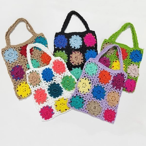 Detail of colorful handmade crochet granny square tote bags with floral patchwork patterns