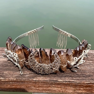 Close-up of raw brown crystal crown with silver wire moon and stag head details