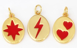 Detailed view of oval gold pendants with red enamel star lightning and heart patterns