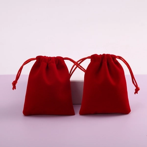 Two red velvet drawstring gift bags for jewelry storage on a clean background