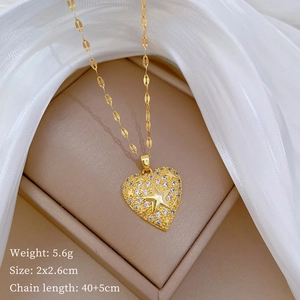 Detail of gold heart pendant necklace with star crystal inlay on soft silk fabric