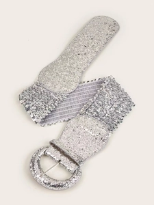 Detail of silver sequined elastic wide waist belt with circular glitter buckle on white