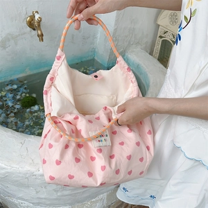 Detailed view of pink heart canvas tote bag with woven handles and internal pocket