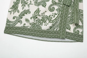 Detail of green paisley print on cotton-linen fabric with stitched hem and tie design